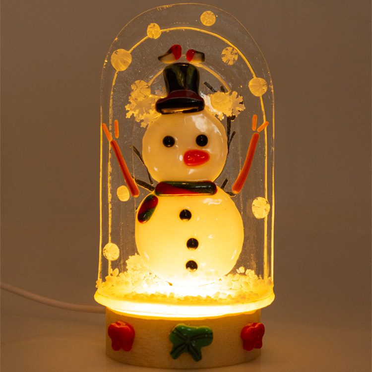 Illuminated fused glass snowglobe with snowman, top hat and glowing base