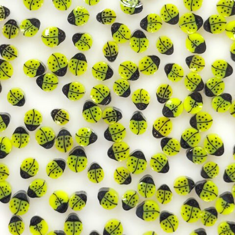 Close-up of yellow-green and black ladybug murrine showing spotted pattern, Oceanside 96COE